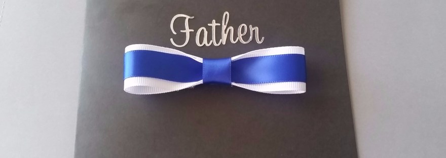 Handmade Fathers day card on black cardstock with a blue and white bow